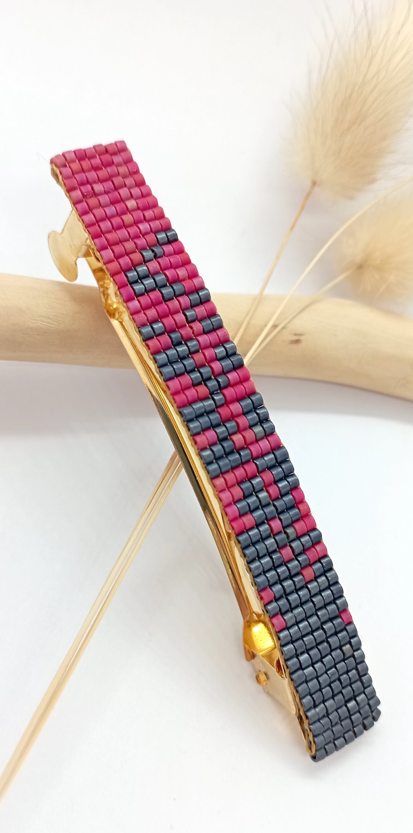 Barrette pour cheveux en métal dorée et en perles tissées grises et roses.