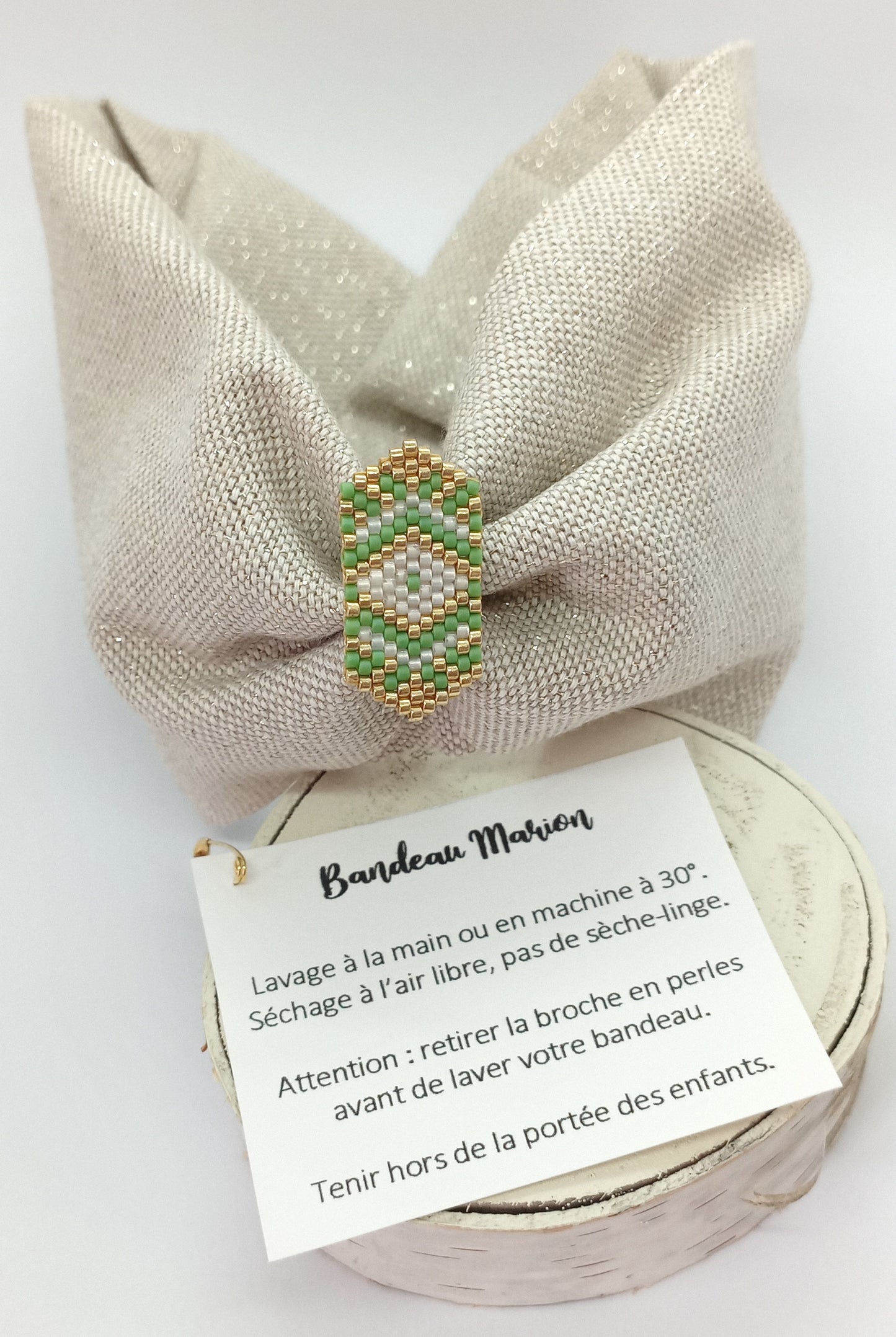 Bandeau en tissu beige et dorée et broche en perles tissée verte et dorée.