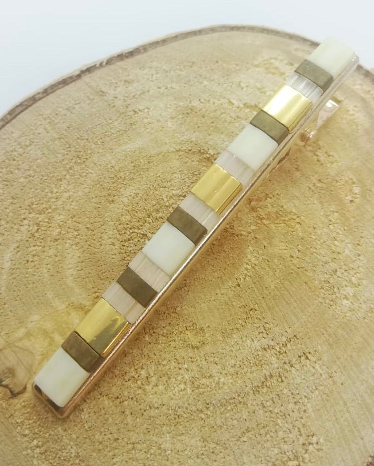 Barrette pour cheveux en perles miyuki tila posé sur un rond de bois